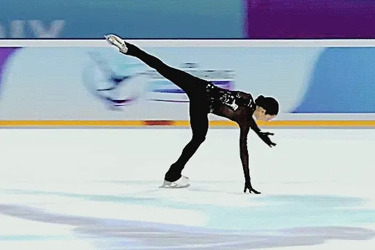 sofia dzepka gliding on one leg in a circular motion, one hand down to touch the ice