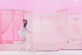 piki riding on scooters on the video set, one in front of the other