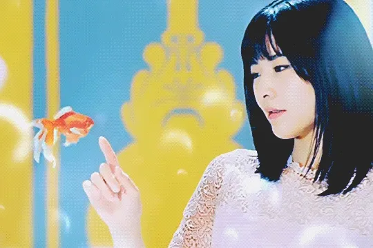 ogata risa in tsubaki factory's 'fuwari koi dokei' music video, turning her head towards a koi fish that swims away from her