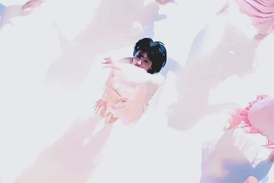 overhead shot of asakura kiki dancing with the group and raising her hand towards koi fish that swim around her
